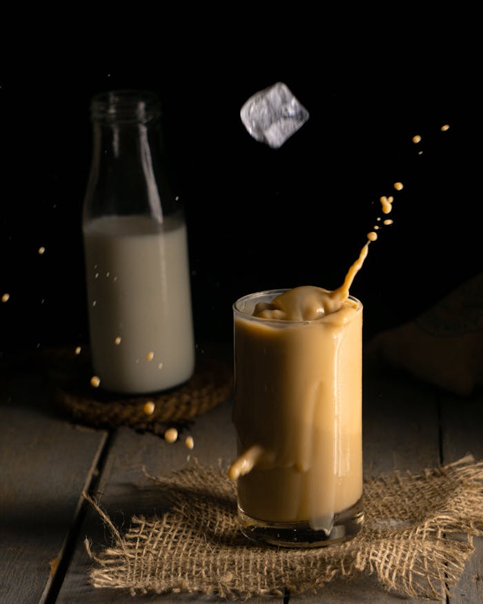 services-01 Captivating black background image of milk tea splash showcasing ice cube motion and milk in the background.